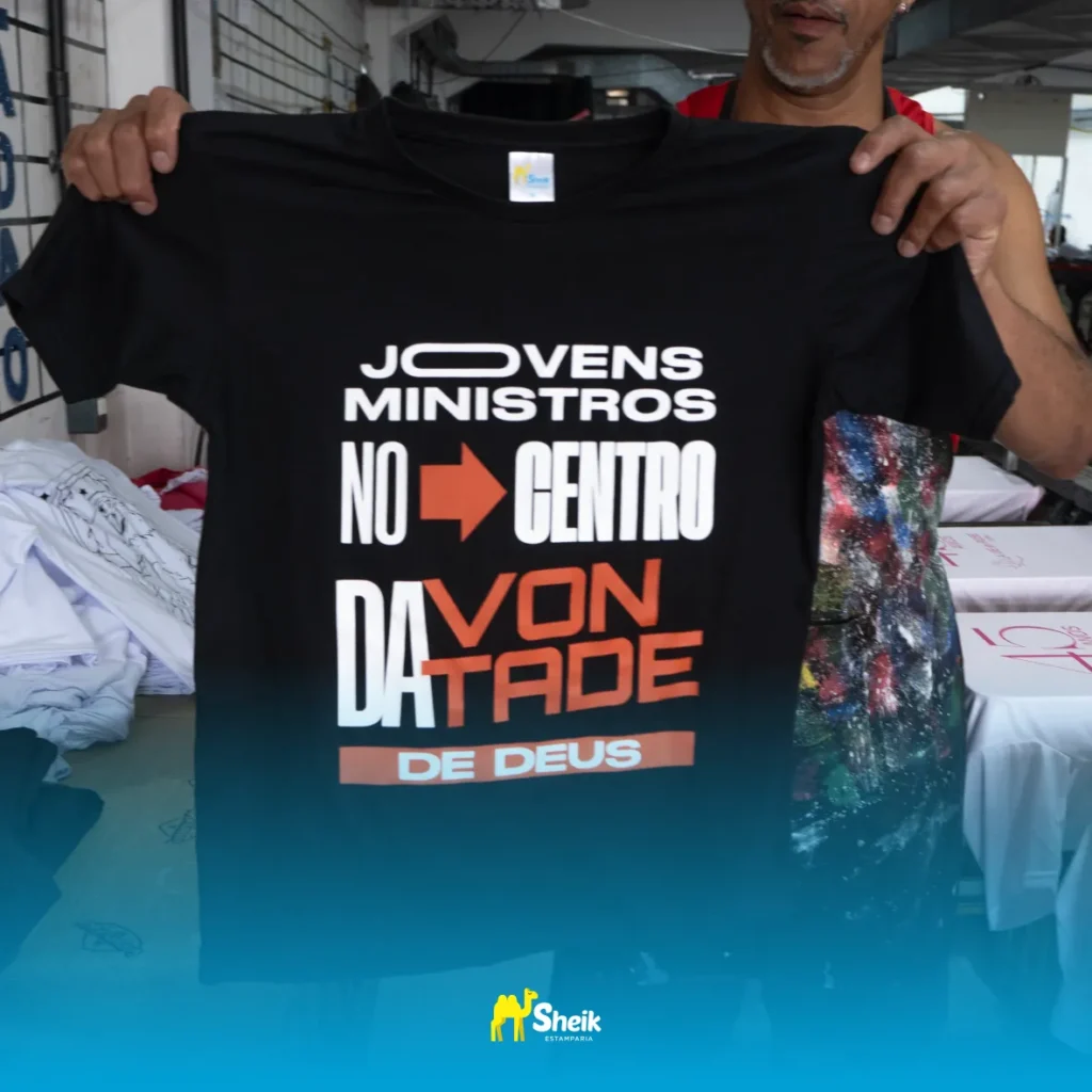 Homem segurando uma camisa estampada.