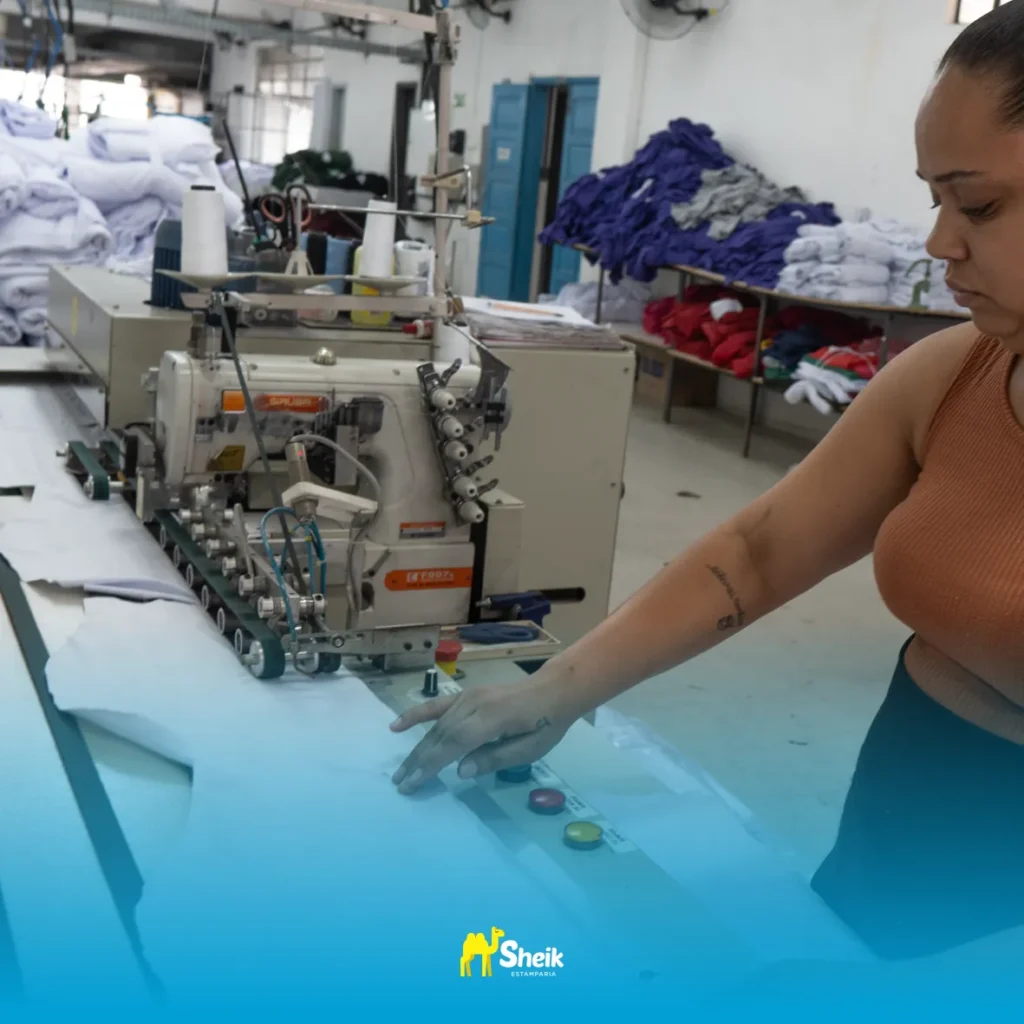 Colaboradora cortando o molde de uma camisa.