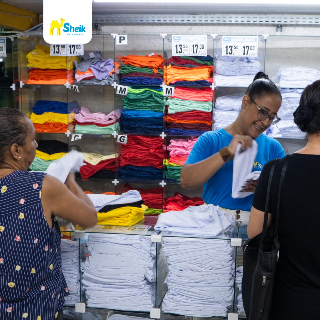 Colaboradora da Sheik Estamparia atendendo clientes no balcão